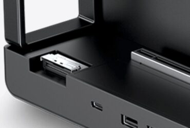 Close-up of a black electronic device with an open front drawer and a metal connector inside.