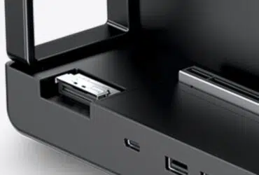 Close-up of a black electronic device with an open front drawer and a metal connector inside.