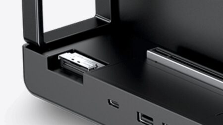 Close-up of a black electronic device with an open front drawer and a metal connector inside.