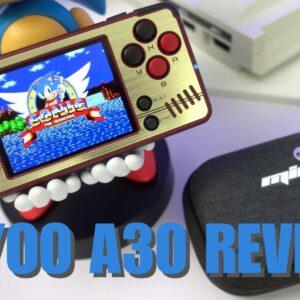 retro-style handheld gaming console, the Miyoo A30, is displayed prominently. Its gold and black design features a screen showing Sonic the Hedgehog, surrounded by classic gaming controls including a D-pad, circular buttons, and an analog stick. The device is held up by a playful figurine with large teeth visible. In the foreground, a black protective case bears the Miyoo A30 logo. The image showcases the compact size and nostalgic appeal of the console, emphasizing its portability and classic gaming capabilities. Bold blue text at the bottom reads "MIYOO A30 REVIEW," indicating the purpose of the image. The overall composition highlights the blend of modern technology with retro gaming aesthetics, appealing to enthusiasts of classic video games