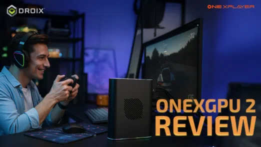 Smiling gamer using a controller while playing a racing game on a desktop setup connected to the ONEXGPU 2 eGPU, with DroiX and OneXPlayer logos and the text 'ONEXGPU 2 REVIEW' prominently displayed.