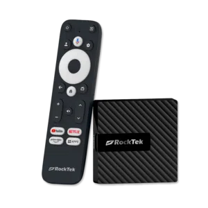 RockTek GB1 Android TV box shown alongside its dedicated remote control. The compact device has a sleek, textured design. The remote features a circular navigation pad, voice control button, and dedicated buttons for popular streaming services like YouTube, Netflix, and Prime Video, along with an 'Apps' button for quick access to installed applications
