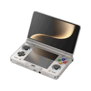 An angled, open view of a light grey AYN Thor handheld gaming console with a clamshell design, against a dark, featureless background. The top screen is open, displaying a soft golden abstract image. The bottom half of the device shows the controls, including a black D-pad, black analog sticks, and face buttons in red, blue, green, and yellow, resembling the classic "rainbow" controller aesthetic. Both the top and bottom screens are reflective, mirroring the golden light.