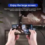 A lifestyle image titled Enjoy the large screen showing a person holding a smartphone horizontally while playing a high action video game The phone is connected via a USB C cable to a large TV in the background which mirrors the same game graphics The text describes Real time screen projection for mobile game graphics smooth without stuttering with a wider visual range