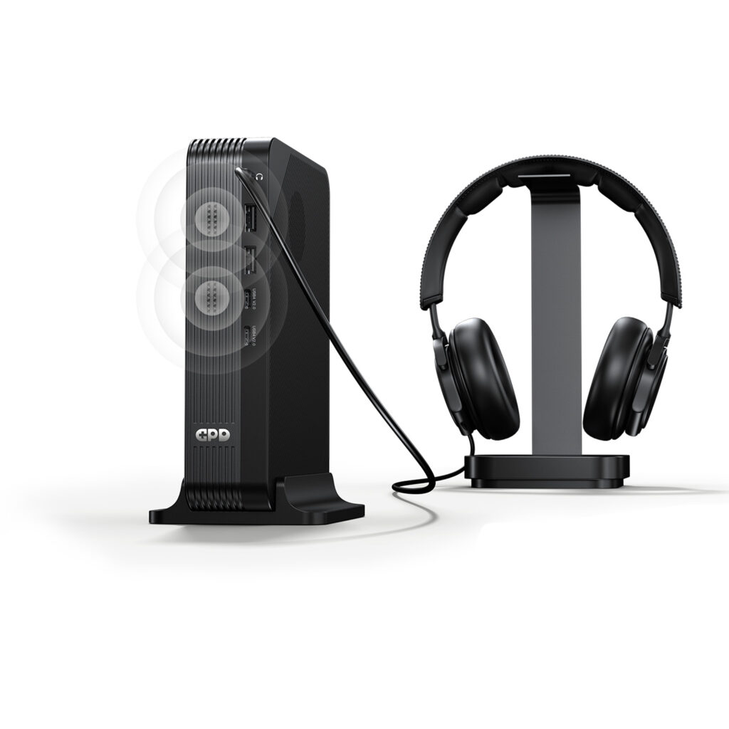 GPD BOX 5 A marketing image showing the GPD device vertically docked. A cable connects its top audio jack to a pair of black over-ear headphones sitting on a stand. Faint white concentric circles emanate from the front of the unit, illustrating the built-in speaker functionality alongside the wired audio output.