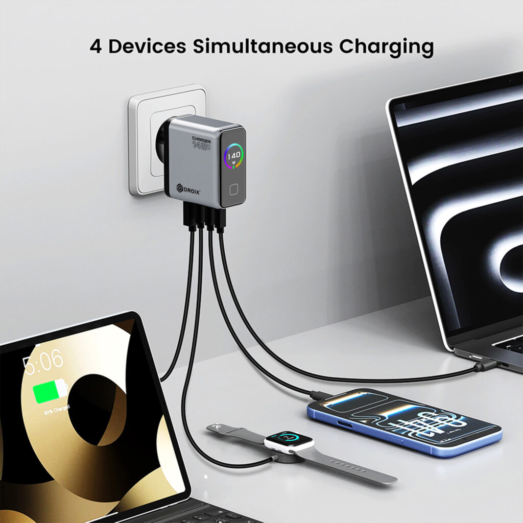 - DROIX A DROIX 140W USB-C Wall Charger plugged into a wall socket, simultaneously charging four devices including a laptop, tablet, smartphone, and smartwatch. The image highlights the