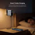 Wall mounted smart charger beside a bed with a phone charging on the nightstand