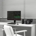 Matte black GPD Box GPD Mini PC on white desk, front-angled beside code monitor and triple-fan eGPU
