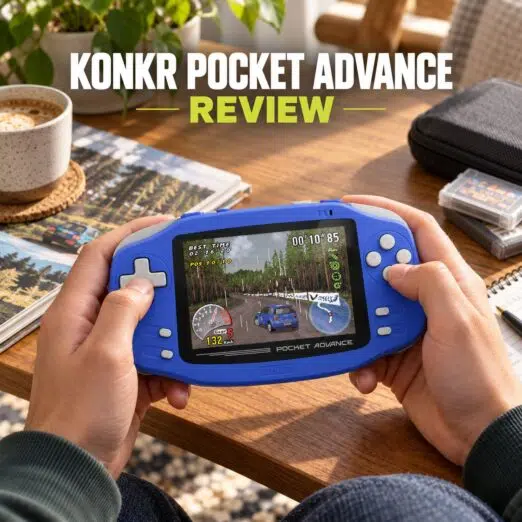 KONKR Pocket Advance Review 11 A person holding a blue handheld gaming device styled like a Game Boy Advance, playing a 3D rally racing game. Large bold text at the top reads "KONKR POCKET ADVANCE" in white with "REVIEW" highlighted in lime green below. The device is displayed on a wooden desk alongside a cup of coffee, game cartridges, and a notebook in a cozy indoor setting.