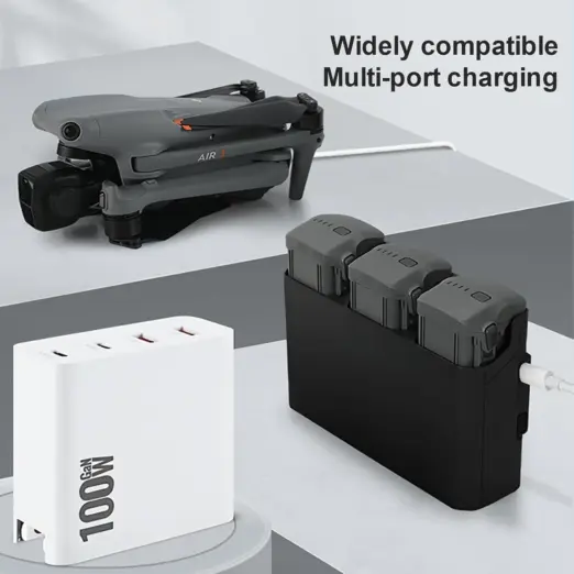 A multi-port 100W GaN charger simultaneously supplying power to a folded DJI Air 3 drone and a three-slot drone battery charging hub